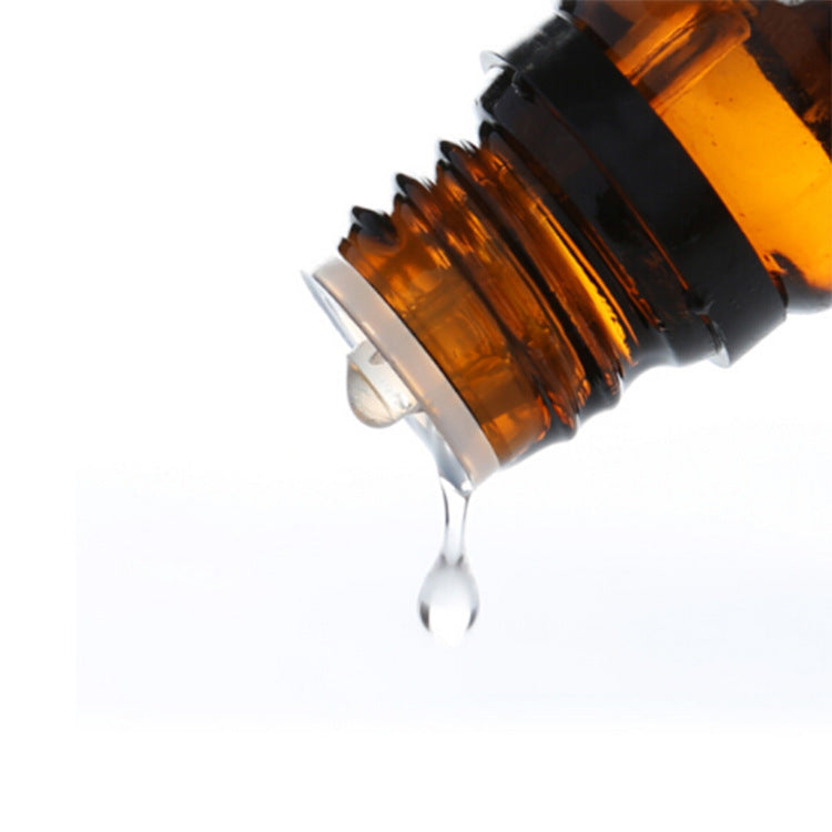 Close-up of tea tree essential oil bottle with drop, used for spa, aromatherapy, massage, moisturize and shrink pores.