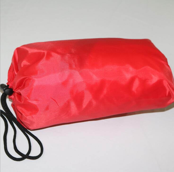 Red polyester running parachute resistance umbrella packed in a drawstring pouch for outdoor exercise and speed training.