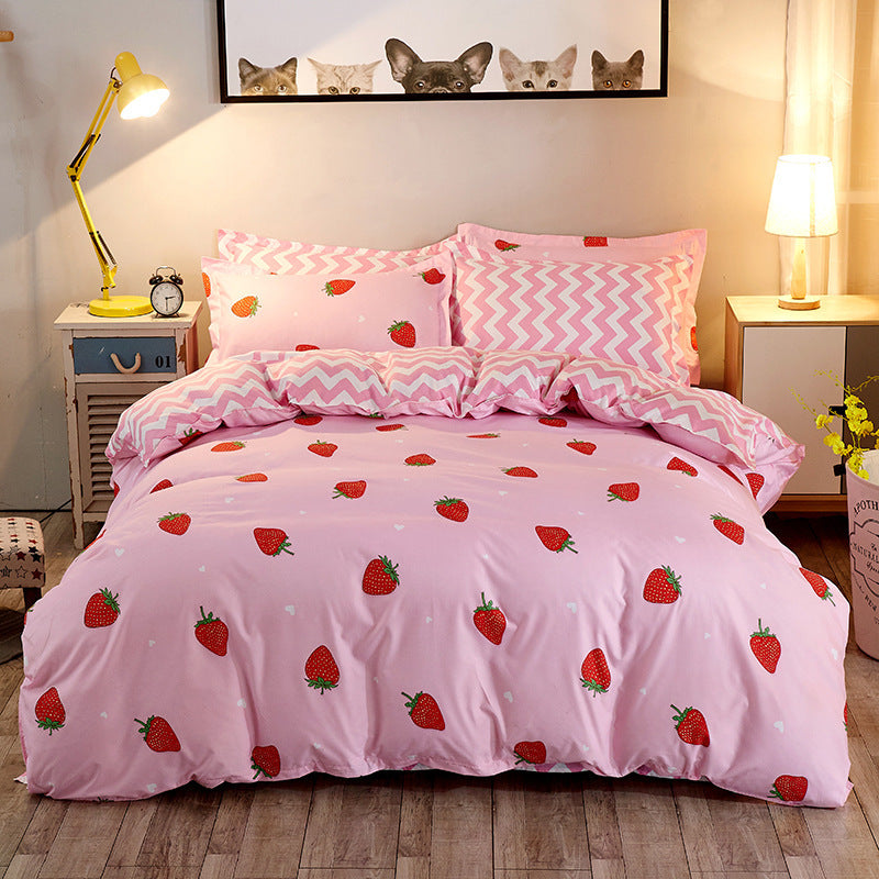 Pink strawberry-themed cotton bed sheet set with chevron pillows in cozy bedroom setting.
