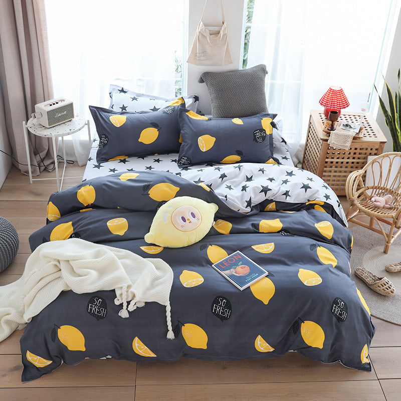 Cozy bedroom with lemon-patterned bedding set, featuring a dark quilt cover, pillowcases, and a playful plush toy on top.