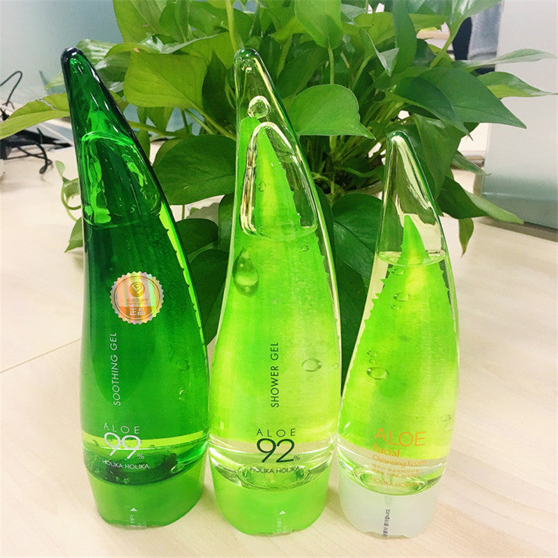 Aloe vera gel bottles on a table with green plants in the background, showcasing natural moisturizing skincare products.
