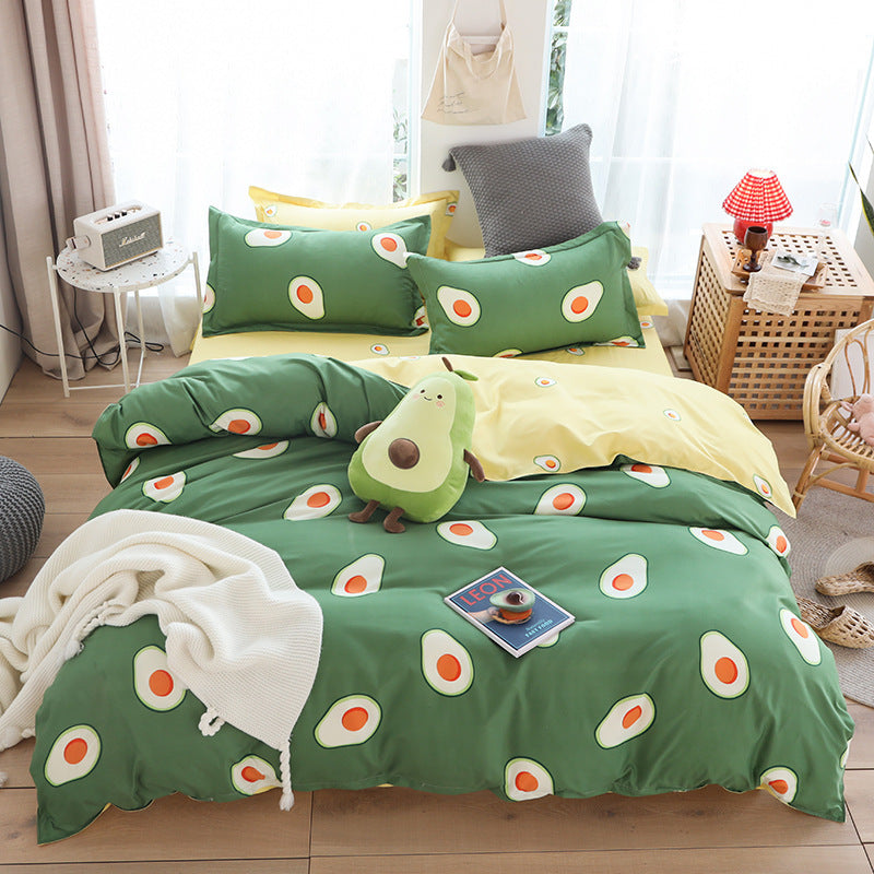 Avocado-themed cotton sheet set with pillows and blanket in cozy bedroom setting.