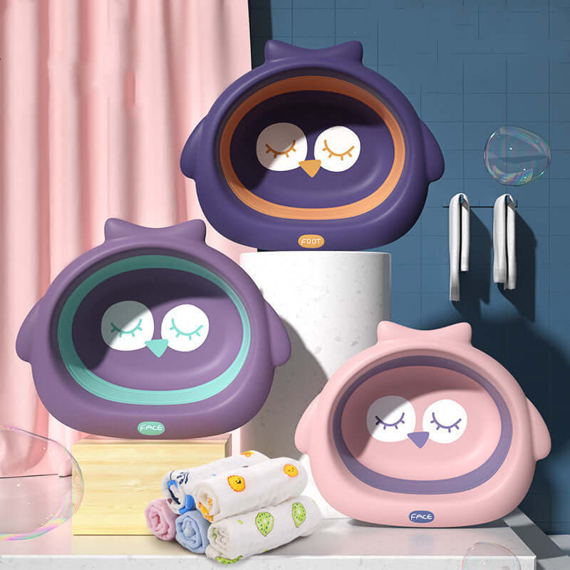 Owl-shaped baby basins in soft fog powder, dark night purple, and dream purple colors with rolled children's towels in a bathroom setting