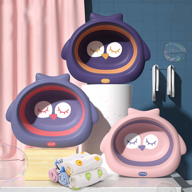 Baby buttocks-shaped small basins in soft fog powder, dark night purple, and deep blue colors, displayed with children's towels in a bathroom setting.