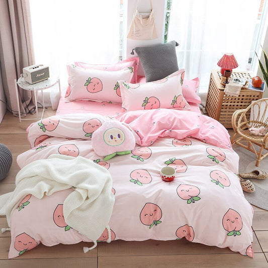 Pink peach-themed cotton bed sheet set with matching pillows in a cozy bedroom setting.