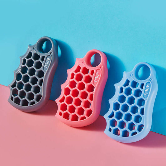 Honeycomb Grip Fitness Exercise Silicone Equipment in Grey 60LB, Pink 20LB, and Sky Blue 40LB against a pink and blue background.