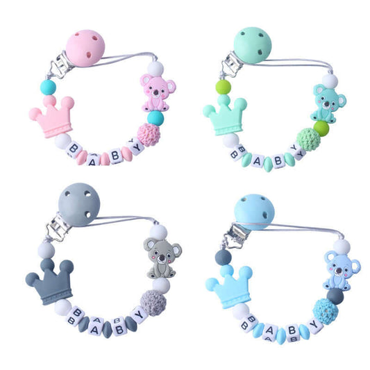Colorful baby pacifier clips with alphabet beads spelling BABY, featuring silicone and wooden materials shaped like crowns and cute animal designs.